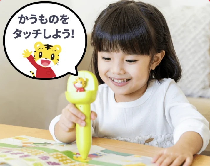 音の出るペンで絵本にタッチして学ぶ様子